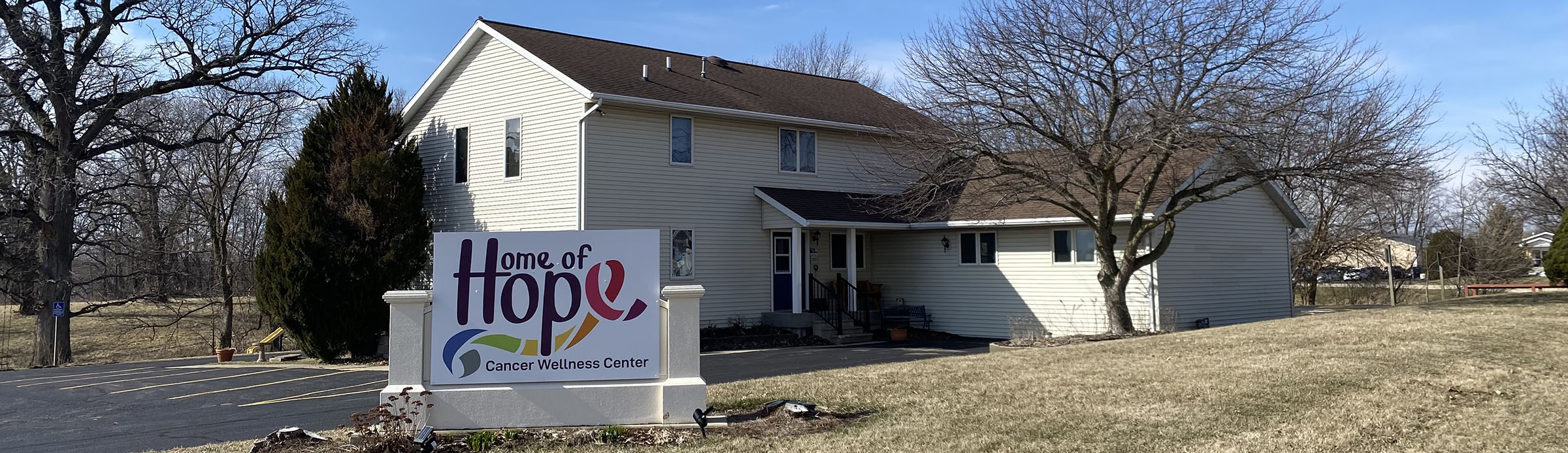 A large house that has a sign in front of it that says "Home of Hope"